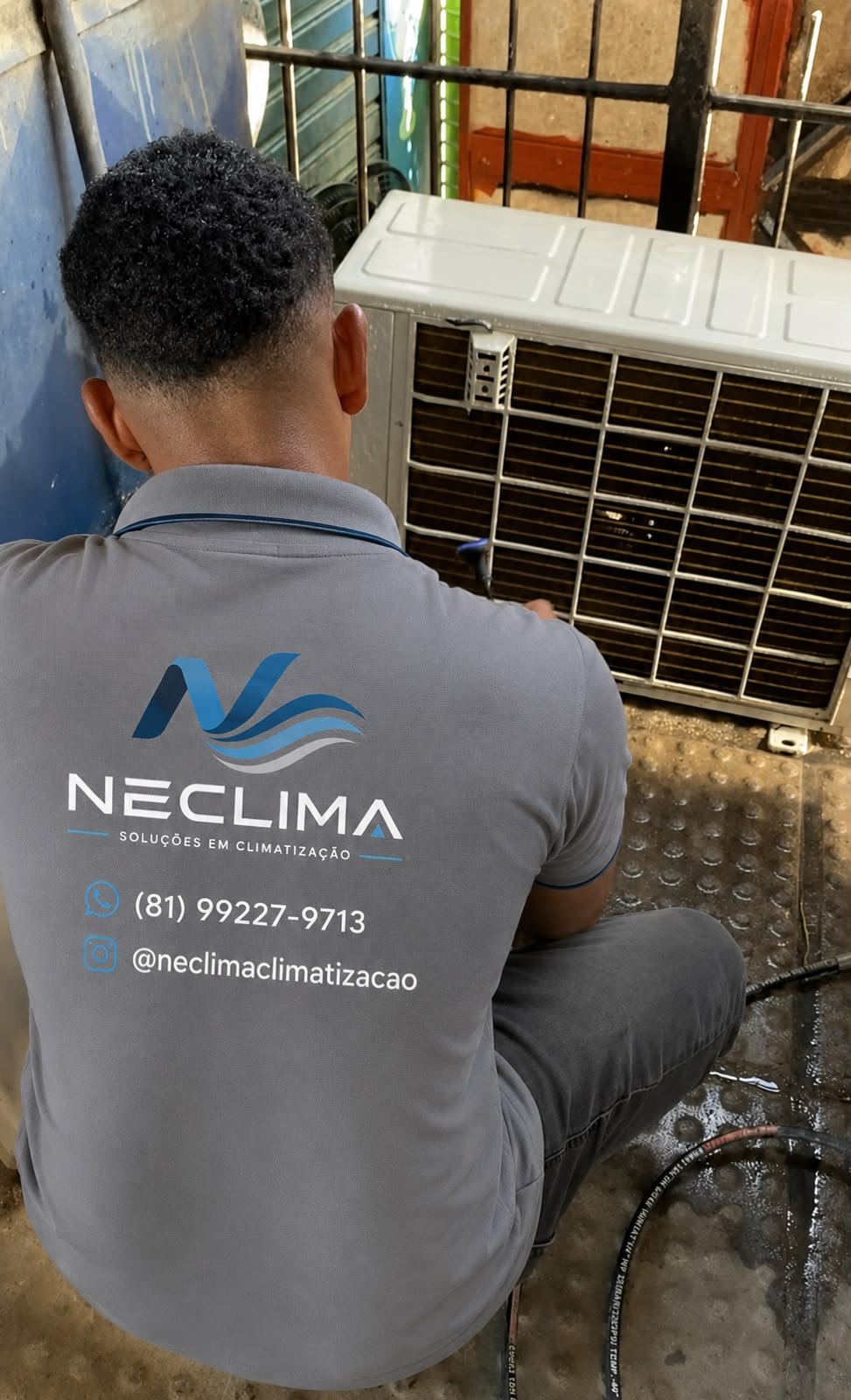 Técnico uniformizado da Neclima higienizando a unidade externa de um ar-condicionado
